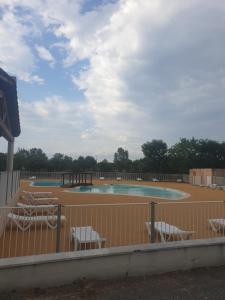 een zwembad met stoelen en een hek bij RÉSIDENCE LES PORTES DES CÉVENNES in Sauve