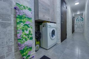 eine Waschküche mit Waschmaschine auf dem Flur in der Unterkunft YourHouse на Гагарина Утепова - экономичнее квартиры, уютнее гостиницы in Almaty