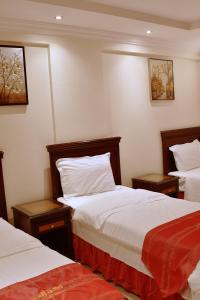 um quarto de hotel com duas camas e duas mesas em Rokn Al Omor Apartments by Quiet Rooms em Riade