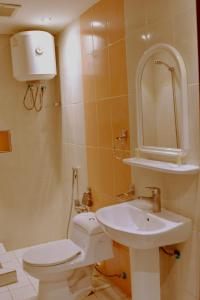 uma casa de banho com um WC branco e um lavatório. em Rokn Al Omor Apartments by Quiet Rooms em Riade