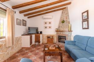 sala de estar con sofá azul y chimenea en La Monticana en Frigiliana