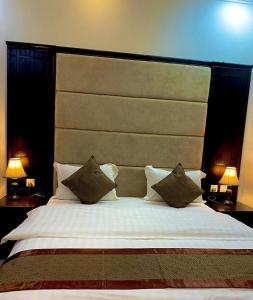 - une chambre avec un grand lit et une grande tête de lit dans l'établissement Moon Gate 2, à Yanbu