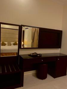 a bedroom with a desk and a mirror at Moon Gate 2 in Yanbu