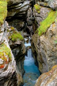 una pequeña cascada en medio de un cañón rocoso en Alpenrose, en Innertkirchen