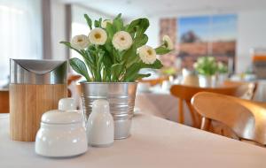 ein Tisch mit einer Blumenvase darauf in der Unterkunft centra Hotel in Schwedt