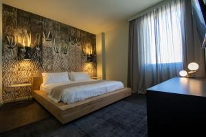 una camera con letto e parete con opere d'arte dei cervi di Arco Vecchio Urban Suite - Epoca Collection a Lecce