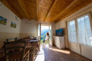 een kamer met een tafel en een raam en een vrouw bij La Beppa - Casa Vacanza in Pontremoli