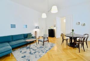a living room with a blue couch and a table at Apartment Wien in Vienna