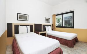 TangkilにあるHotel Syariah Cordovaのベッドが2つと窓があるホテルの部屋