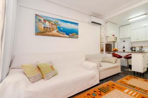 ein Wohnzimmer mit einer weißen Couch und einer Küche in der Unterkunft Apartamento Playa del Cura in Torrevieja