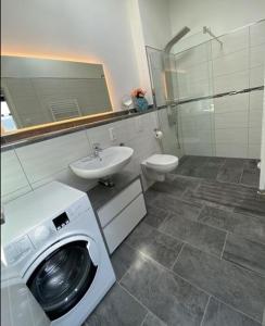 a bathroom with a washing machine and a sink at Ferienwohnung Auenblick in Eisenach