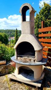a stone pizza oven sitting next to a bench at Ferienhaus Waldblick in Sonnenbühl