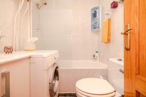 ein weißes Bad mit einem WC und einer Waschmaschine in der Unterkunft Apartamento Playa del Cura in Torrevieja