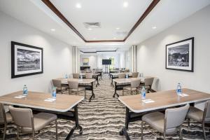 Staybridge Suites Denver International Airport, an IHG Hotel في دنفر: قاعة اجتماعات مع طاولات وكراسي ومنضدة