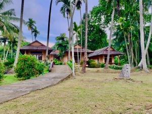 a house with palm trees in front of it at Koh Mook Resort in Ko Mook