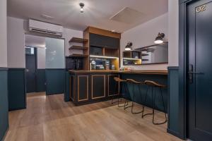 eine Küche mit blauen Schränken und eine Bar mit Hockern in der Unterkunft Uma Suites Atocha in Madrid