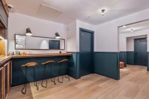 a bar in a room with blue cabinets and stools at Uma Suites Atocha in Madrid