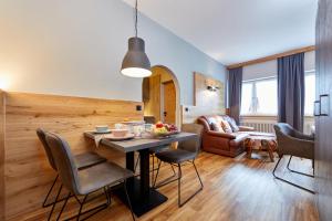 cocina y sala de estar con mesa y sillas en Gästehaus Buchenhof, en Grainau