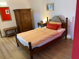 ein Schlafzimmer mit einem Bett mit einem roten Kissen darauf in der Unterkunft Altstadthotel Wilde Rose in Eppingen