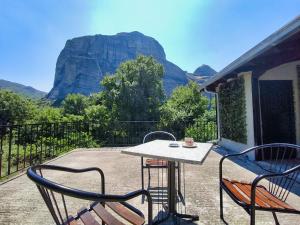 卡兰巴卡Zosimas House的一张桌子和几把椅子，可以欣赏到山景