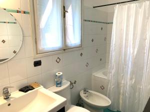 bagno con lavandino, servizi igienici e specchio di Appartamenti Levanto Centro a Levanto