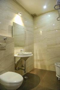 Hotel Taj Heights في آغْرا: حمام مع مرحاض ومغسلة