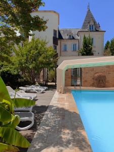 une maison avec une piscine à côté d'un bâtiment dans l'établissement Au Grand Hôtel de Sarlat - Pavillon de SELVES, à Sarlat-la-Canéda