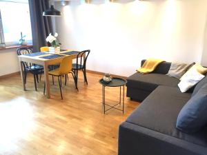 a living room with a couch and a table with chairs at Fregata Apartment Gdynia in Gdynia