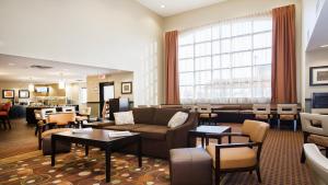 エドモントンにあるStaybridge Suites West Edmonton, an IHG Hotelのリビングルーム(ソファ、テーブル、椅子付)