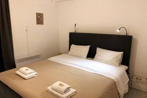 una camera da letto con un letto e due asciugamani di quiet and central FLAT with private backyard GARDEN ad Atene