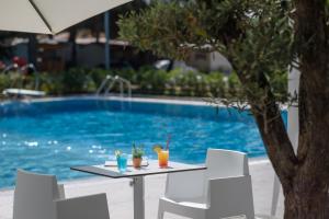 a table with drinks on it next to a swimming pool at Maistra Camping Valkanela Mobile homes in Funtana +37 photos
