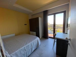 a bedroom with a bed and a large window at Villa Torre degli Ulivi in Corigliano Calabro