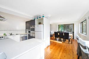 a kitchen with white appliances and a dining room at Bonny Beach House in Bonny Hills