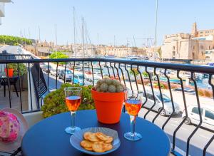 維托里奧薩的住宿－Vittoriosa' Seafront 2 Bed Highly Furnished Apartment，阳台上的桌子上放着两杯葡萄酒和食物