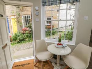 a small table and chairs in a room with a window at Oakridge Cottage in Whitby +4 photos
