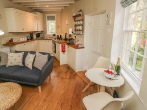a kitchen and living room with a couch and a table at Oakridge Cottage in Whitby