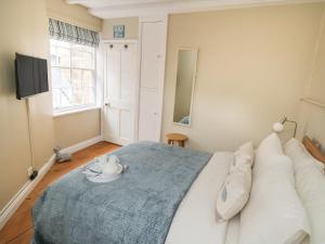 a bedroom with a large bed with a blue blanket at Oakridge Cottage in Whitby
