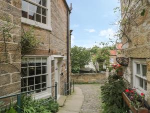 an alleyway between two brick buildings with flowers at Oakridge Cottage in Whitby