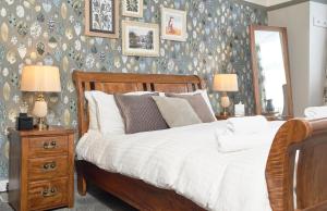 een slaapkamer met een bed, 2 lampen en een spiegel bij The Angel Inn Hotel in Pershore