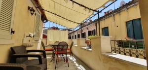 un balcone con sedie e tavoli su un edificio di Fenix Otello Apartments a Venezia