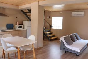 cocina y sala de estar con mesa y sillas en Casa la Barbacana, en Barbastro