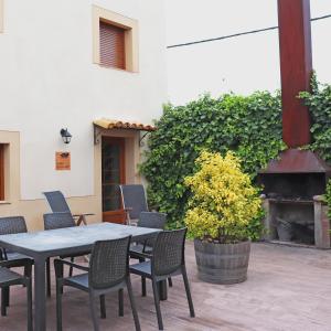 una mesa y sillas en un patio con chimenea en Casa la Barbacana, en Barbastro