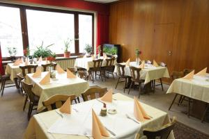 ein Esszimmer mit Tischen und Stühlen mit weißem Tischtuch in der Unterkunft Gasthof Zur Traube in Finkenbach