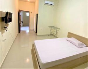 een ziekenhuiskamer met een bed en een televisie bij Pondok Bintang in Biringkanya