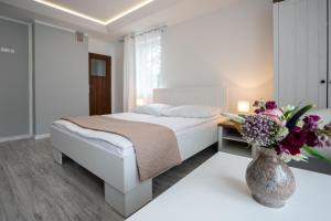 een slaapkamer met een bed en een vaas met bloemen bij Pablo in Niechorze