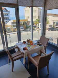 una mesa con comida en ella en una habitación con ventanas en Hotel Nais Beach, en Durrës