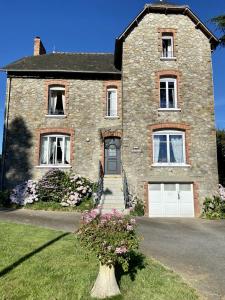 une grande maison en briques avec un garage blanc dans l'établissement Les hortensias, à Grand-Fougeray