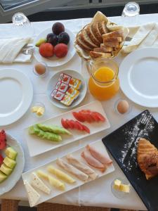 a table topped with plates of food and fruit at Hotel Nais Beach in Durrës