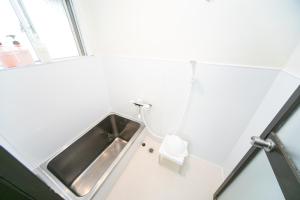 uma casa de banho com um lavatório ao lado de uma janela em Yokkaichi Nishishinchi Hotel em Yokkaichi