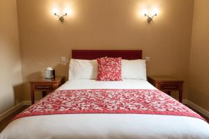 a bedroom with a large bed with a red blanket at Laichmoray Hotel in Elgin